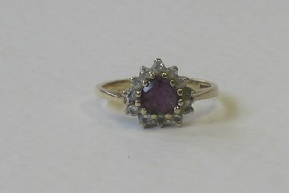 A 9ct gold dress ring set an amethyst supported by white stones