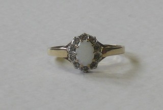 A 9ct gold dress ring set an oval cut opal supported by diamonds