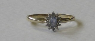 A 9ct gold dress ring set an oval cut Topaz supported by diamonds