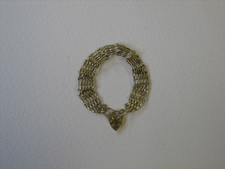 A modern 9ct gold gatelink bracelet with heart shaped padlock