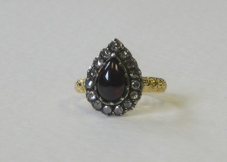 An 18ct gold dress ring set a heart shaped cabouchon garnet supported by diamonds