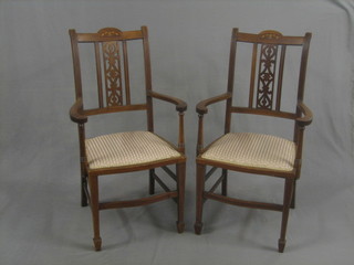 A pair of Edwardian Art Nouveau inlaid mahogany carver chairs with upholstered seats, raised on square supports