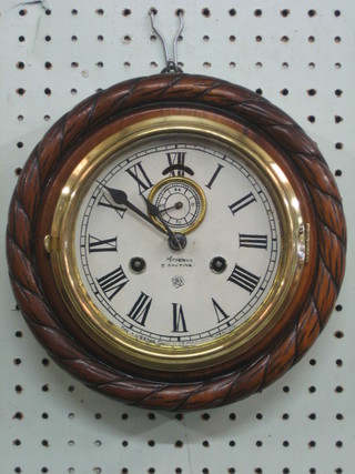 An American 8 day striking wall clock with 5 1/2" circular paper dial with minute indicator, by The Ansonia Clock Co. contained in a carved oak case