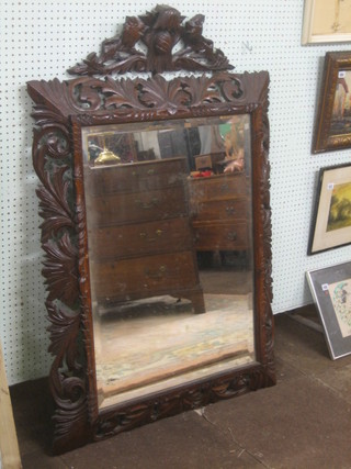A Victorian rectangular bevelled plate wall mirror contained in a carved and pierced oak frame 52"