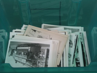A large collection of various re-print black and white photographs of Trams, contained in a green plastic box