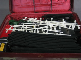 A red fibre suitcase containing a collection of various Scalextrix