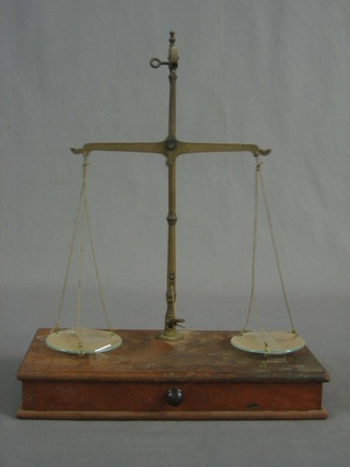A pair of gold scales raised on a mahogany stand