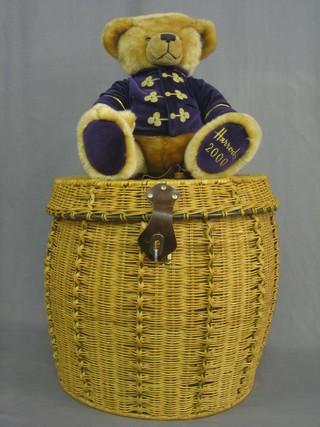 A Harrods 2000 teddybear contained in a circular Harrods wicker hamper with hinged lid