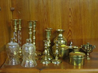 A pair of brass and glass candlesticks, 2 other pairs of brass candlesticks and a collection of brassware