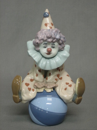 A Lladro figure of a clown seated on a ball, base impressed 5813 7"