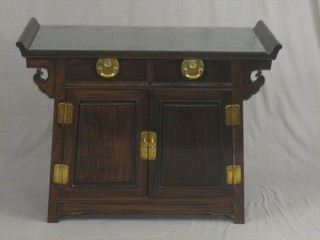 An Eastern hardwood side table, fitted 2 drawers above a double cupboard enclosed by a panelled door, 41"