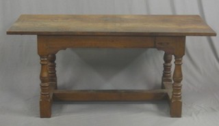 An oak refectory dining table, raised on turned supports with an H framed stretcher 65"