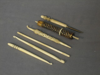 2 ivory needle cases in the form of a parasol 5 1/2", a bodkin with turned ivory handle 4" and 3 ivory crochet hooks