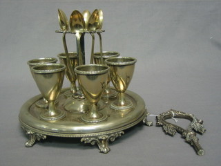 A silver plated 6 piece egg cruet, raised on a stand (handle f)
