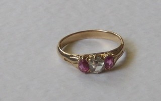 An 18ct gold dress ring set an oval cut diamond supported by 2 rubies