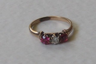 A gold dress ring set diamonds supported by 2 "rubies"
