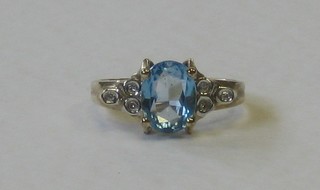 A 9ct gold dress ring set a blue oval cut stone surrounded by diamonds