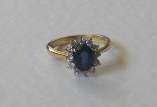 An 18ct yellow gold dress ring set an oval sapphire surrounded by diamonds
