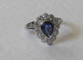 An 18ct white gold dress ring set a pear drop cut sapphire surrounded by diamonds 0.76/1.20ct