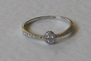 An 18ct white gold dress ring set a small central diamond and with diamonds to the shoulders