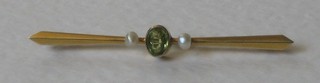 An Edwardian 9ct gold bar brooch set oval cut peridot supported by 2 pearls