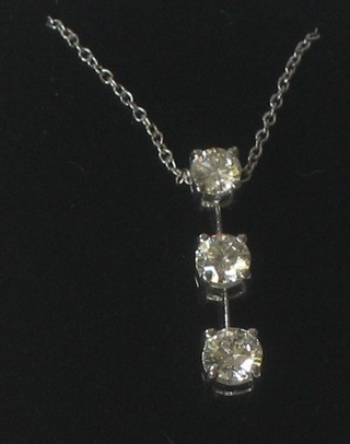 An 18ct white gold pendant set 3 graduated diamonds, approx 0.75ct hung on a fine white gold chain