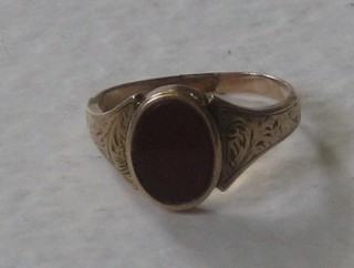 A lady's gold signet ring set an oval hardstone (cut)