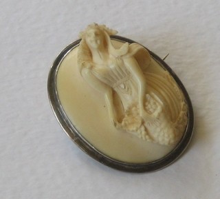 A lady's carved ivory brooch decorated a standing lady on a silver mount
