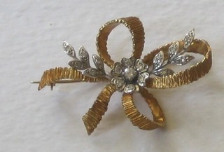 An 18ct gold ribbon brooch set diamonds
