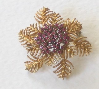 A gold floral spray brooch set red stones