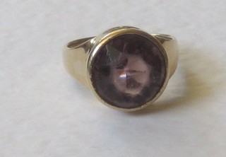 A gold dress ring set a circular amethyst