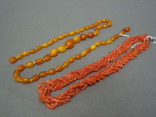A coral necklace together with a string of "amber" beads