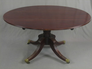 A 19th Century oval snap top mahogany breakfast table, raised on pillar and tripod supports ending in brass caps and castors 55 1/2"