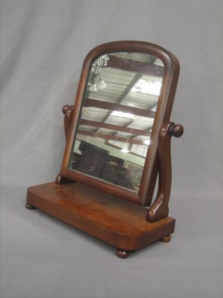 A Victorian mahogany arch shaped plate dressing table mirror contained in a mahogany swing frame 18"
