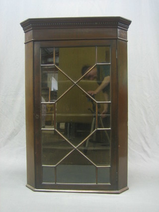 A 19th Century oak and mahogany corner cabinet with moulded and dentil cornice, the interior fitted shelves enclosed by an astragal glazed panelled door 28"