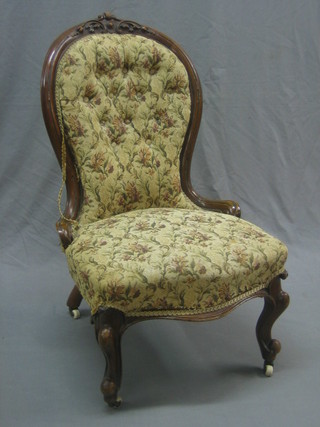 A Victorian carved walnut show frame chair upholstered in buttoned back material