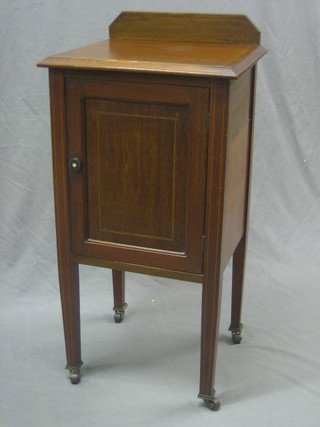 An Edwardian inlaid mahogany pot cupboard enclosed by a panelled door raised on square tapering supports 17"