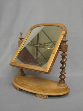 An arched plate dressing table mirror contained in a mahogany frame, raised on an oval base 21"
