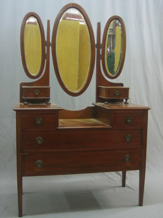 An Edwardian inlaid mahogany dressing table with oval bevelled plate mirrors, the base fitted 2 glove drawers above 2 short and 2 long drawers 38"