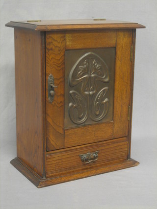 An Art Nouveau oak smoker's cabinet with hinged lid revealing a fitted interior, the base fitted a drawer 12"