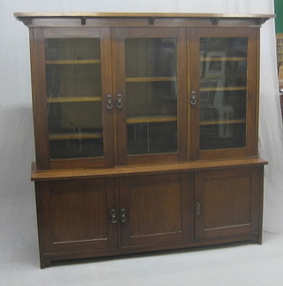 An Art Nouveau mahogany  cabinet on triple cabinet, the upper section with moulded cornice, fitted adjustable shelves enclosed by glazed panelled doors, the base fitted a triple cupboard enclosed by panelled doors 63" 