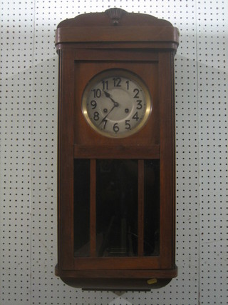 A striking wall clock with silvered dial and Arabic numerals contained in a "walnut" case