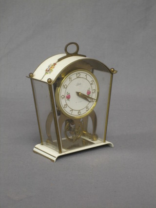 A 1950's German 8 day mantel clock with gilt dial and rose decoration contained in a metal and perspex arch shaped case