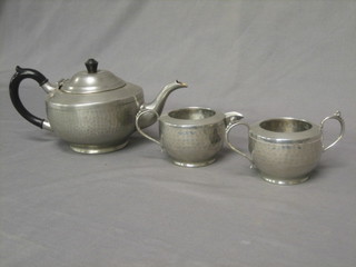 A planished pewter 3 piece tea service by ELL comprising teapot, cream jug and sugar bowl