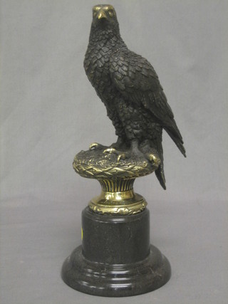 A modern bronze figure in the form of a seated bird of prey, raised on a socle base 13"