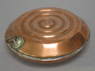 A circular antique copper foot warmer 9"