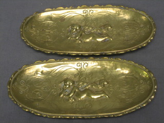 A pair of oval cast brass dishes decorated reclining cherubs raised on 4 paw feet, 6"