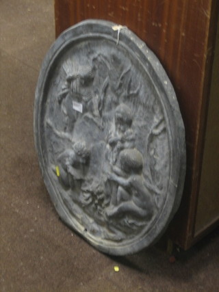 An oval embossed lead plaque depicting cherubs fire making 23"