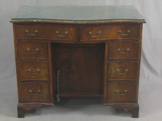 A Georgian style kneehole pedestal dressing table/desk of serpentine outline, fitted 2 long drawers above 4 short drawers, the pedestal fitted a cupboard, raised on bracket feet 36"