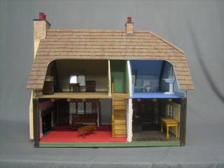A wooden dolls house complete with light furnishings 26"